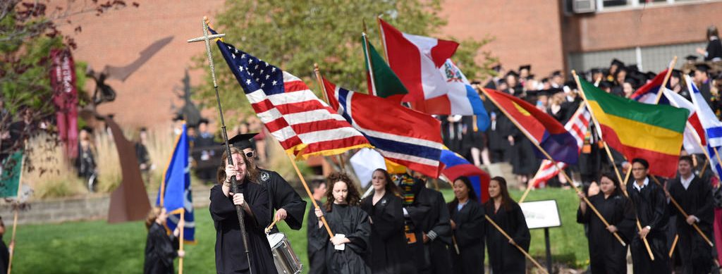 Students carry flags into graduation ceremony at Augsburg University.